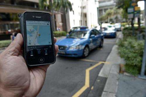 A smartphone displays the Uber app of the timing and availability of taxis within the area at Raffles place financial district i