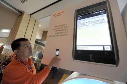 A staff member checks a Lenovo mobile phone display prior to a launching ceremony in Beijing, on September 16, 2009