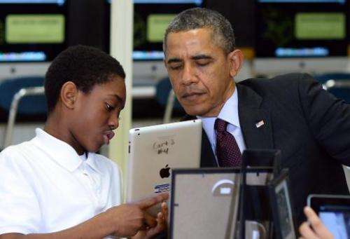 A student shows US President Barack Obama how he is working to create an ebook with an iPad in a classroom at Buck Lodge Middle 