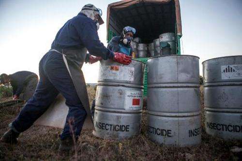 A team prepares pesticide containers, which will be attached to a helicopter, in Tsiroanomandidy, Madagascar on May 7, 2014