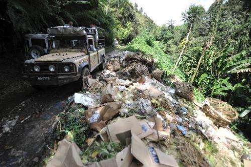 A truck passes piles of rubbish in the Cameron Highlands, Malaysia, on November 19, 2013