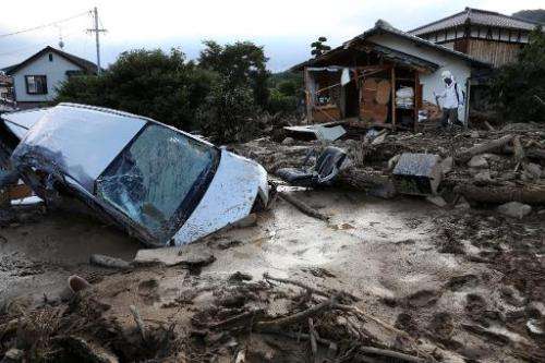A vehicle is buried in mud one day after a landslide hit a residential area in Hiroshima, western Japan on August 21, 2014