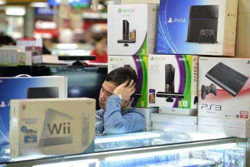 A vendor sells game consoles including Xbox One and Sony's PS4, which they say enter China through unofficial channels, in a maj