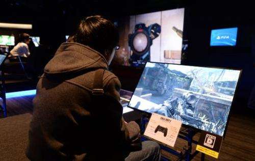 A visitor plays 'Call Duty Ghosts,' a first-person shooter game on Sony's PlayStation 4 game console during an event in Tokyo on