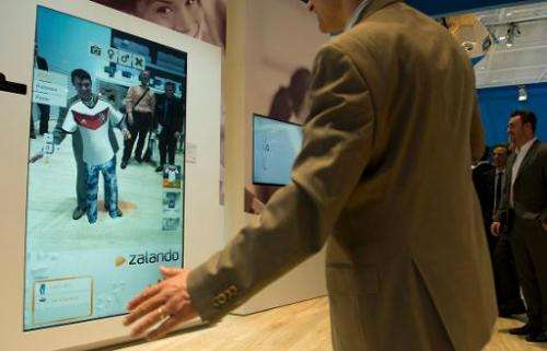 A visitor tries on clothes in a virtual fitting room at the stand of South Korean electronics giant Samsung at the 2014 CeBIT co