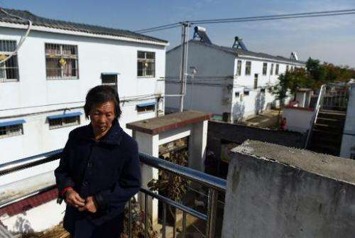 A woman stands among apartments built for villagers relocated to make way for the expansion of the Danjiangkou reservoir, at Lia