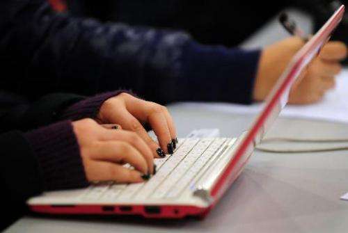 A woman types on the keyboard of her laptop computer in Beijing on January 7, 2010