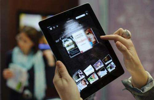 A woman uses an eBook app on an Apple iPad at the Leipzig Book Fair on March 15, 2012