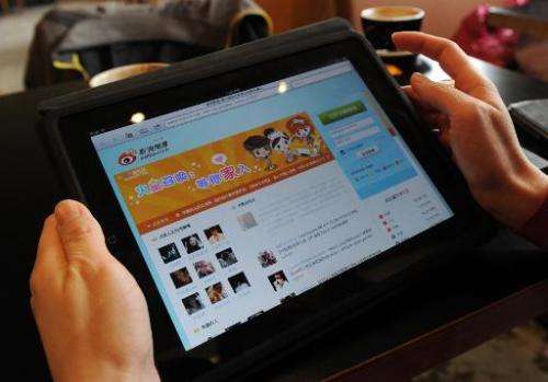 A woman views the Chinese social media website Weibo at a cafe in Beijing on April 2, 2012