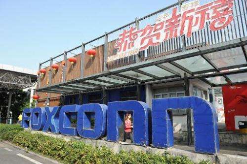 A young woman walking past a Foxconn recruitment point in Shenzhen, south China's Guangdong province on February 22, 2013