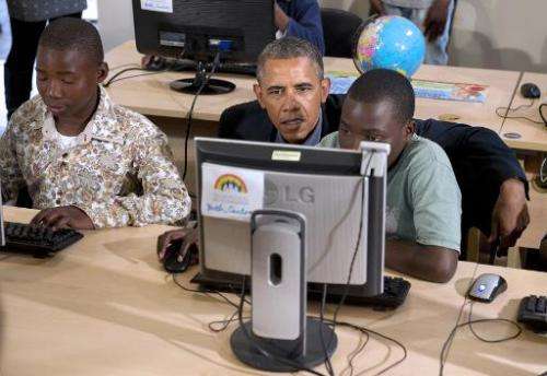 Barack Obama sits at a computer as he tours a classrom at the Desmond Tutu HIV Foundation Youth Centre in Cape Town, South Afric