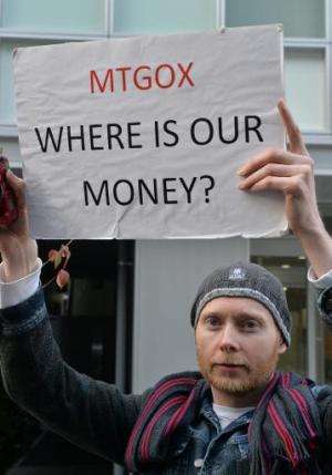 Bitcoin trader Kolin Burges from Britain holds up a placard to protest against Tokyo-based bitcoin changer MtGox in front of the