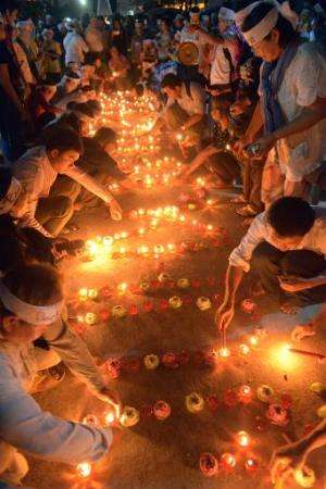 Cambodians light candles as they pray for the missing Malaysia Airlines flight MH370 in Phnom Penh on March 17, 2014