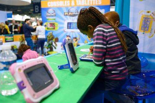 Children play with digital tablets on October 19, 2013, during the &quot;Kidexpo&quot; show at the Porte de Versailes exhibition