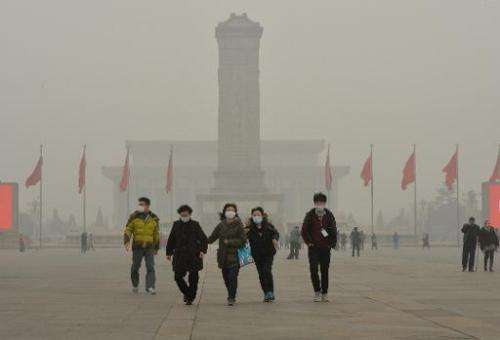 Chinese tourists wearing face masks visit Tiananmen Square as heavy air pollution continues to shroud Beijing on February 26, 20