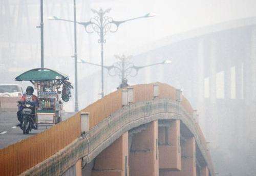 Commuters cross a bridge as thick haze blankets Pekanbaru in Indonesia on September 16, 2014