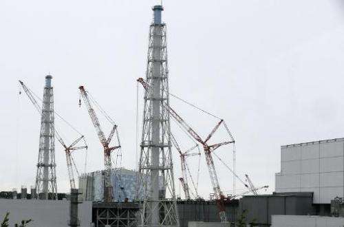 Cranes work at the tsunami-crippled Tokyo Electric Power Co.'s Fukushima Daiichi Nuclear Power Plant in Okuma, Fukushima Prefect