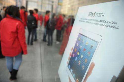 Customers are seen waiting for an Apple store to open in Shanghai, on December 7, 2012