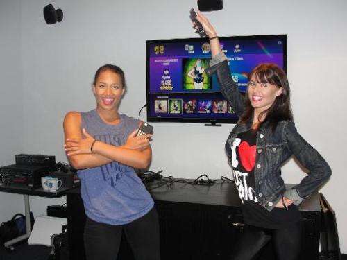 Dancers Alysha Young and Kandiss Lewis use smartphones as controllers in the 'Just Dance Now' video game on September 15, 2014 i