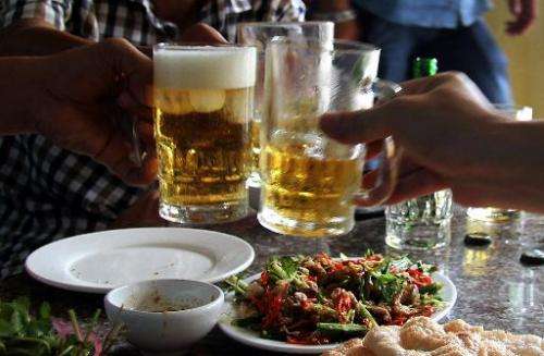 Diners enjoy a dish of cat meat while drinking beer at a restaurant in Hanoi on June 19, 2014
