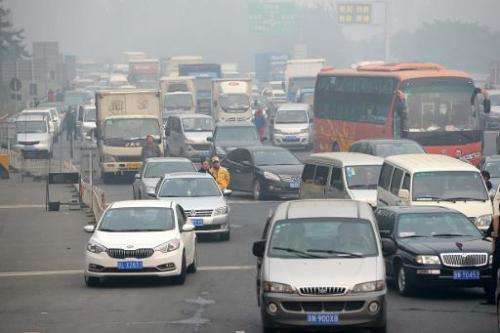 Drivers wait at the entrance of a highway in Beijing as most of the highways were closed due to the heavy smog on October 9, 201