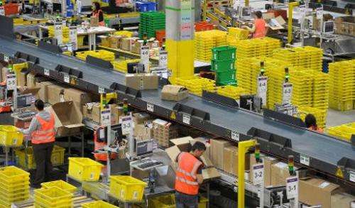 Employees work at an Amazon logistics center on March 26, 2014 in Leipzig, eastern Germany