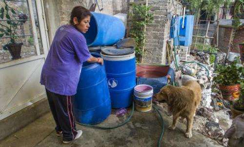 Fabiola Vargas prepares to fill a container with water in the community of Tehuixtitla in southern Mexico City on April 29, 2014