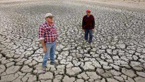 Farmer Marshall Rodda (L) and Gilbert Fryatt (R) stand in an empty dam during the country's worst drought in a century in the Au