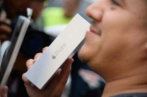 First in line Francisco Naranjo holds up his new iPhone 6 Plus, outside the Apple store in Pasadena, California on the first day