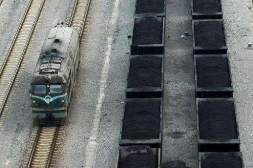 Freight cars (right) filled with coal parked inside a coal mining facility in Huaibei, in northern China's Anhui province on Mar
