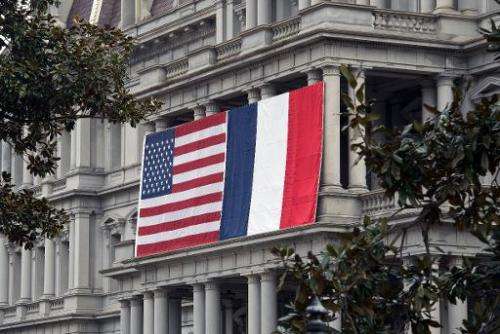French and US flags hang on the Eisenhower Executive Office Building of the White House, in Washington, DC, on February 7, 2014,