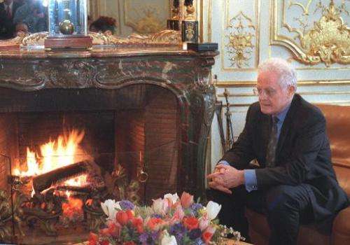 French former Prime Minister Lionel Jospin warms himself next to a fire in his Matignon office in Paris in 1998