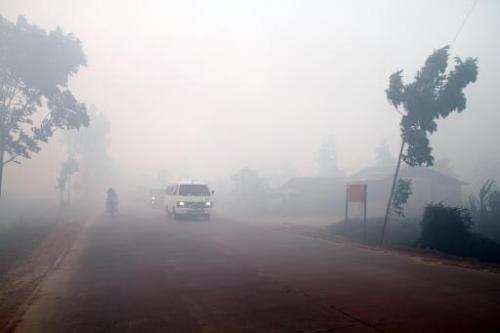 Haze from forest fires blankets a road in Dumai in Indonesia's Sumatra island on June 22, 2014