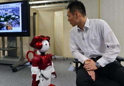 Hitachi's humanoid robot EMIEW2 has a conversation with an employee during a demonstration at the company's central laboratory i