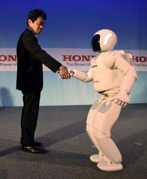 Honda's Satoshi Shigemi works with Asimo Robot at a news conference demonstration on April 16, 2014 in New York