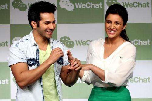 Indian Bollywood actors Varun Dhawan (L) and Parineeti Chopra joke during the launch of the WeChat messenger application in Mumb