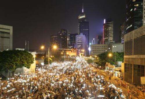 In this long exposure photo, pro-democracy demonstrators hold up their mobile phones during a protest near the Hong Kong governm