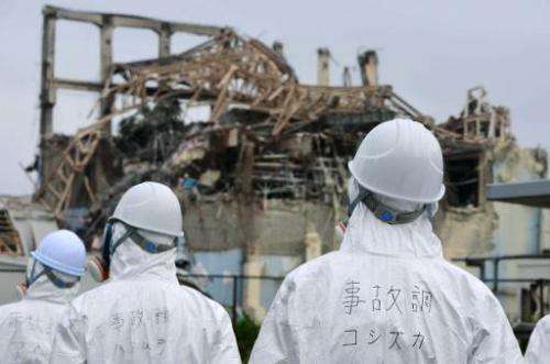 Japanese inspectors look at the damaged building housing reactor number three at the Fukushima nuclear facility at Okuma, on Jun
