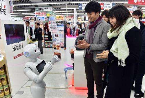 Japanese telecom giant Softbank's humanoid robot Pepper introduces customers to Nestle's coffee machines at an electric shop in 