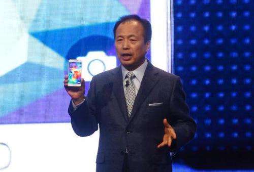 JK Shin, head of Samsung Mobile Communications, presents a Galaxy S5 smartphone during a press conference at the Mobile World Co