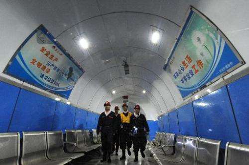 Laborers walk inside a coal mining facility in Huaibei, in northern China's Anhui province, on March 4, 2014