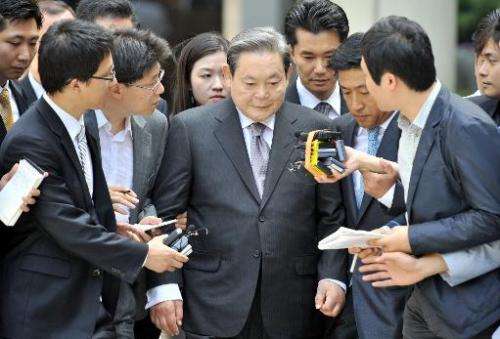 Lee Kun-Hee (centre), former Samsung Group chairman, leaves after his trial at the Seoul High Court in Seoul on August 14, 2009