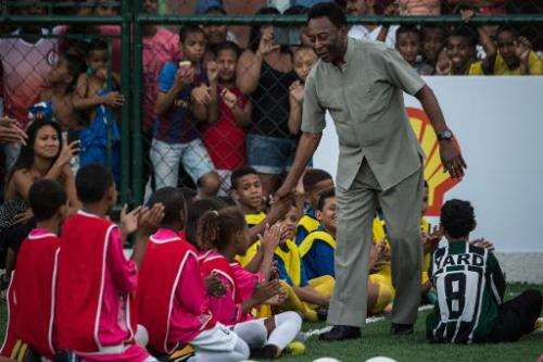 Legendary Brazilian former football player Pele greets children during the inauguration ceremony of the new football pitch insta