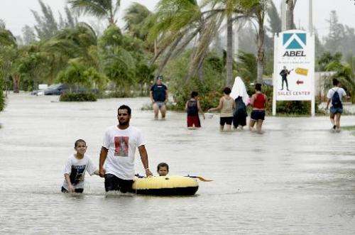 Local residents wade through flooded streets due to Hurricane Katrina, on August 26, 2005, in Miami, Florida