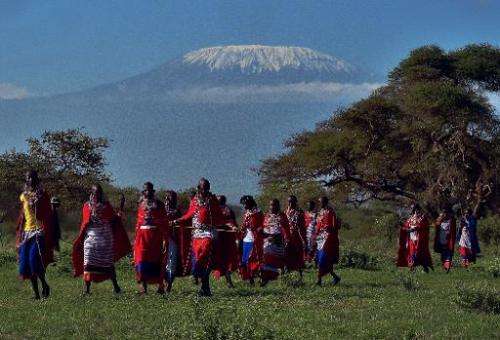 Maasai women walk past Mount Kilimanjaro in Kimani, Kenya on December 13, 2014
