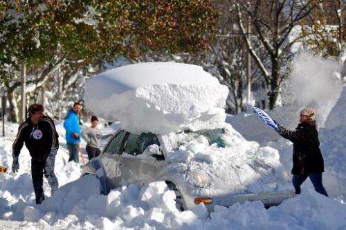 Michael Palmer and Carin Schultz work to clear her car of snow and remove it from Union street on November 20, 2014 in the subur