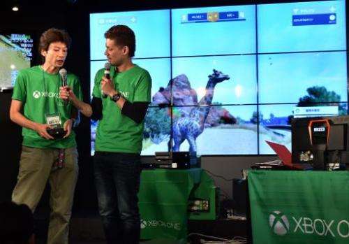 Microsoft Japan employees demonstrate video game console Xbox One, at a video game cafe in Tokyo, on September 3, 2014, on the e