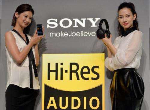 Models display Japanese electronics giant Sony's digital audio player 'Walkman ZX-1' (L) and headphones 'MDR-1', as Sony unveils
