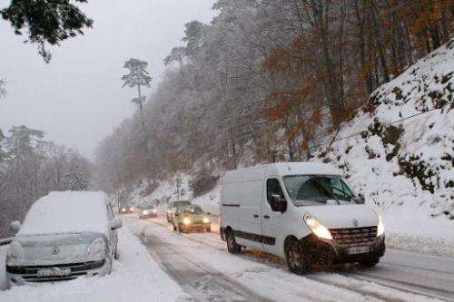 Motorists drive cars on a snow-covered road on November 21, 2013 at the Vizzavona mountain pass, near Bocognano, on the French M