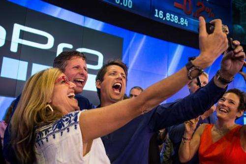 Nick Woodman (R), founder and CEO of GoPro, takes a selfie with coworkers during the company's initial public offering at the Na